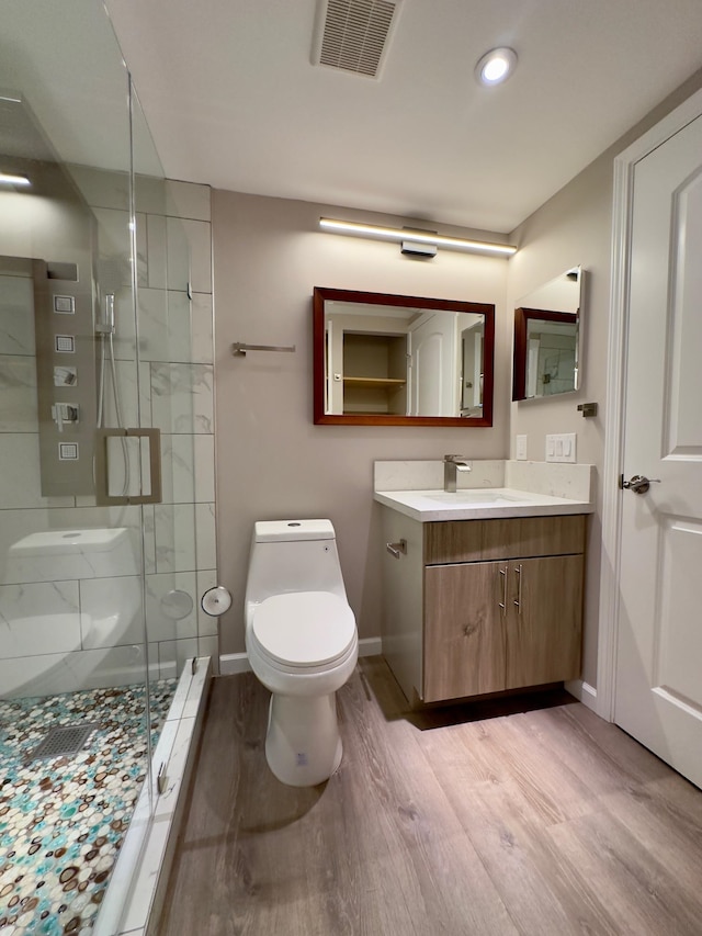 bathroom featuring hardwood / wood-style floors, vanity, toilet, and an enclosed shower