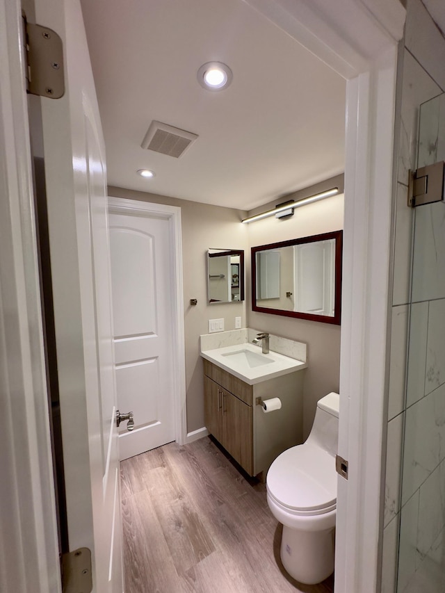 bathroom with hardwood / wood-style floors, vanity, and toilet