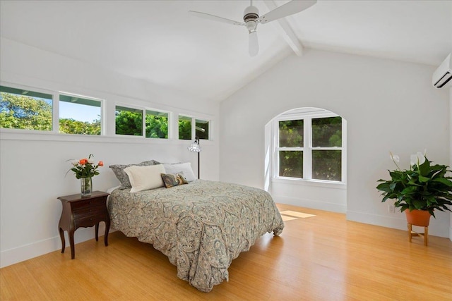 bedroom with light wood finished floors, multiple windows, and lofted ceiling with beams