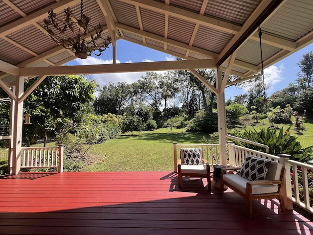 wooden terrace with a ceiling fan and a lawn