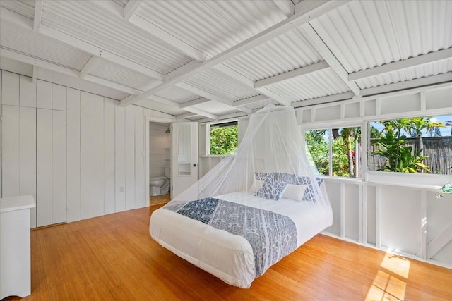 bedroom featuring beamed ceiling and wood finished floors