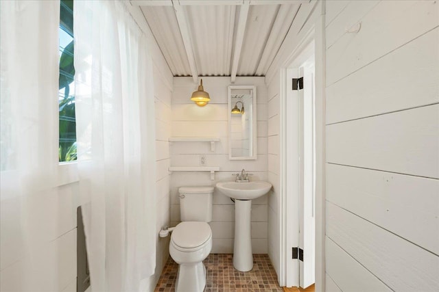 half bathroom with tile patterned floors and toilet