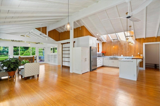 kitchen featuring light wood-style flooring, a sink, high end refrigerator, white cabinetry, and open floor plan