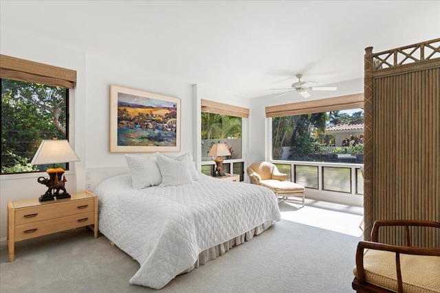 carpeted bedroom with ceiling fan and multiple windows