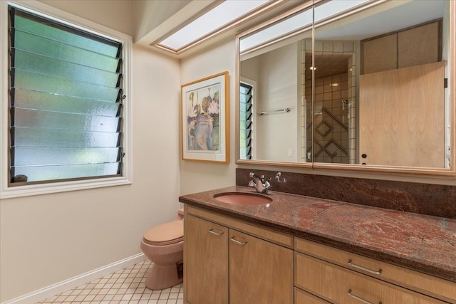 bathroom with tile patterned flooring, vanity, toilet, and tiled shower