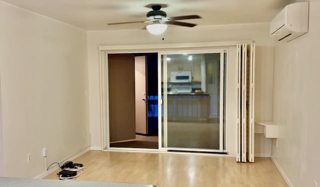 doorway with hardwood / wood-style floors, a wall mounted AC, and ceiling fan