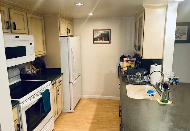 kitchen featuring sink, light brown cabinetry, white appliances, and light hardwood / wood-style flooring