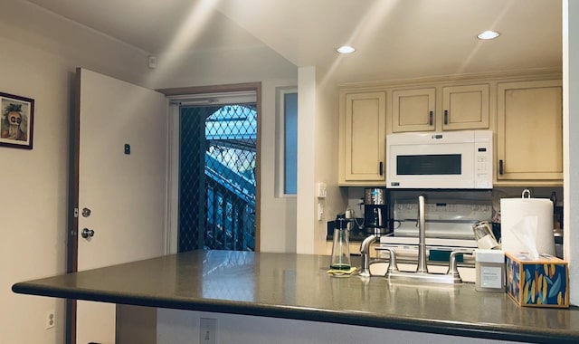 kitchen featuring range with electric stovetop and cream cabinetry