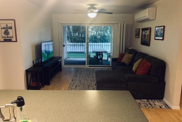 living room with wood-type flooring, an AC wall unit, and ceiling fan