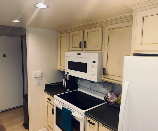 kitchen with white appliances and light hardwood / wood-style flooring