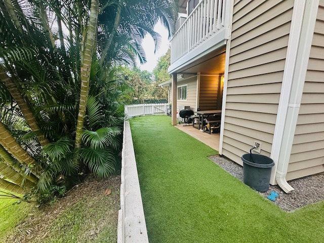 view of yard with a balcony and a patio