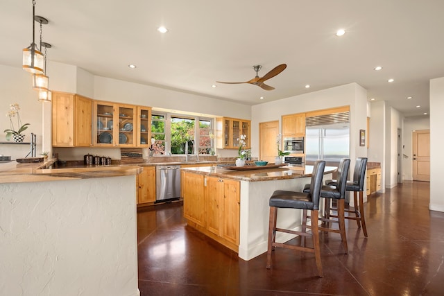 kitchen with light brown cabinetry, appliances with stainless steel finishes, glass insert cabinets, a kitchen island, and a kitchen bar