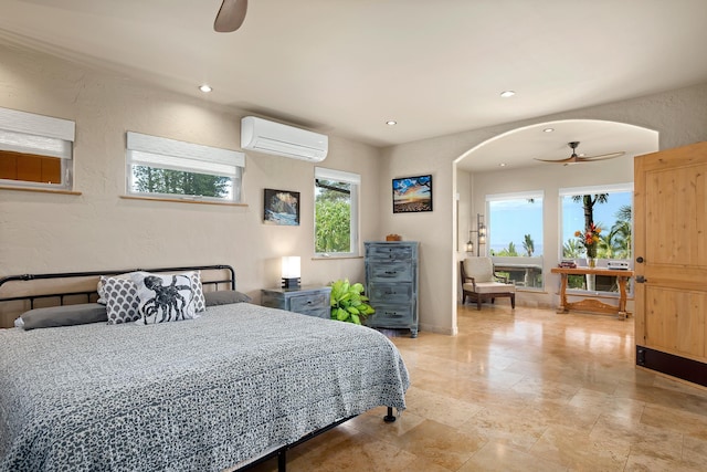 bedroom featuring arched walkways, baseboards, a textured wall, a wall mounted AC, and recessed lighting