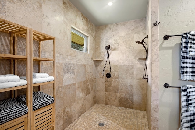 full bathroom featuring tiled shower and a textured wall