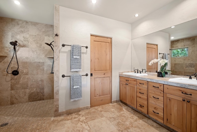 bathroom featuring recessed lighting, double vanity, a sink, and walk in shower