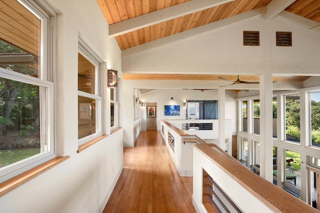 corridor with vaulted ceiling with beams, light wood-type flooring, wooden ceiling, and baseboards