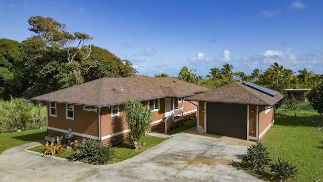 ranch-style house featuring a garage, driveway, a front lawn, and a shingled roof