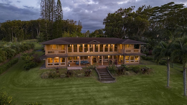 rear view of house featuring a lawn and a patio area