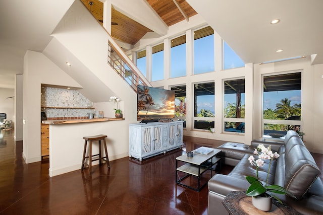 living area featuring wooden ceiling, recessed lighting, a towering ceiling, baseboards, and beamed ceiling