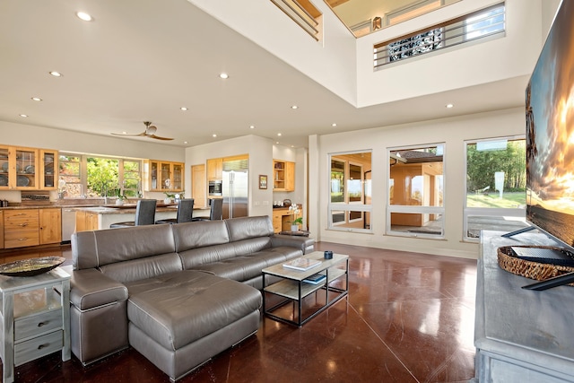 living area featuring plenty of natural light, a high ceiling, and recessed lighting