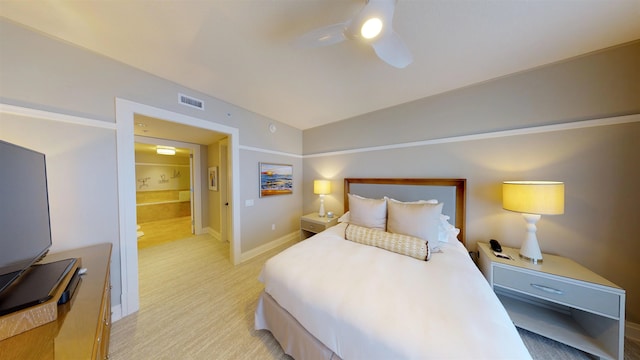 bedroom with ceiling fan, ensuite bath, light carpet, and vaulted ceiling