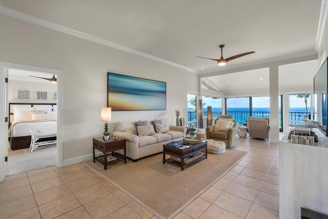 living room with light tile patterned floors, a ceiling fan, baseboards, a water view, and crown molding