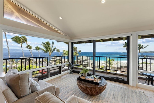 sunroom / solarium featuring plenty of natural light, lofted ceiling, and a water view