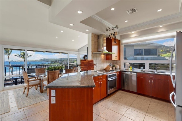 kitchen featuring tasteful backsplash, visible vents, appliances with stainless steel finishes, a peninsula, and wall chimney exhaust hood