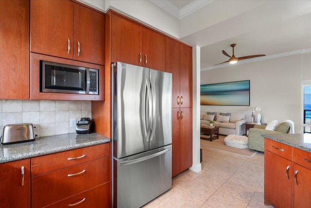 kitchen featuring light tile patterned floors, a ceiling fan, stainless steel appliances, crown molding, and backsplash