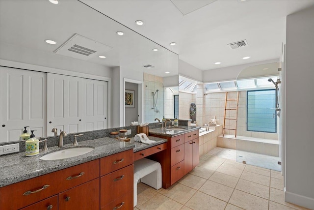 bathroom with visible vents, a garden tub, a tile shower, tile patterned flooring, and vanity