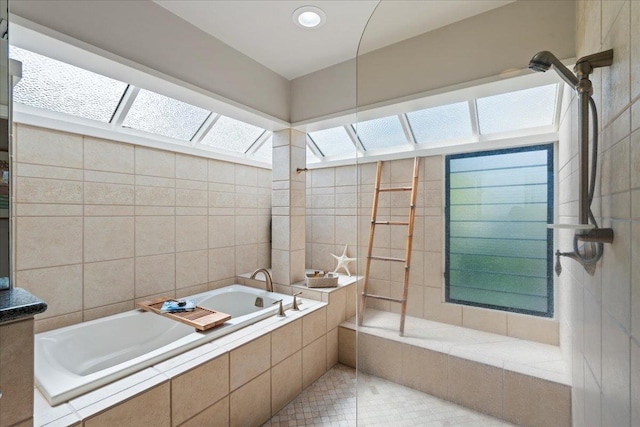 bathroom featuring a bath, tiled shower, and tile walls