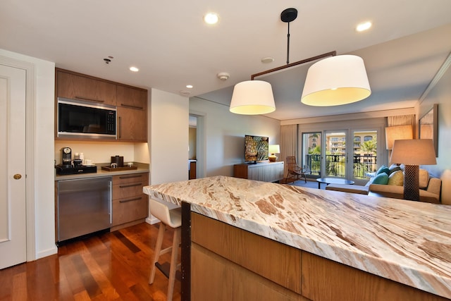 kitchen featuring black microwave, dark hardwood / wood-style flooring, dishwasher, and decorative light fixtures