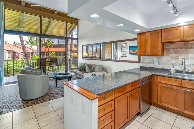 kitchen with backsplash, sink, dishwasher, and kitchen peninsula