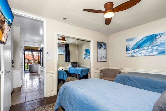 tiled bedroom featuring ceiling fan and a closet