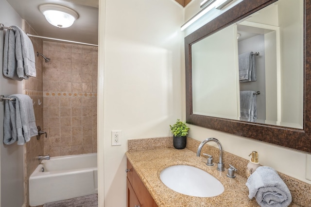 bathroom featuring tiled shower / bath and vanity