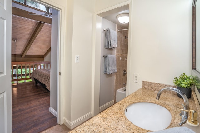 bathroom featuring hardwood / wood-style flooring, ceiling fan, wooden ceiling, tiled shower / bath, and sink