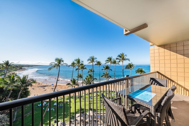 balcony with a water view and a beach view