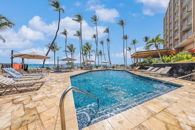 view of swimming pool with a water view and a patio area