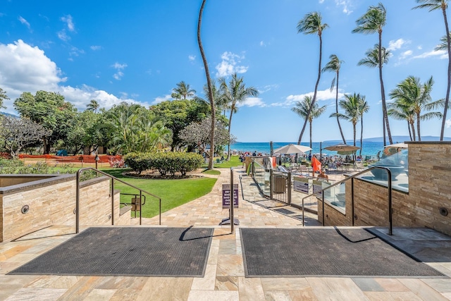 view of home's community with a water view and a yard