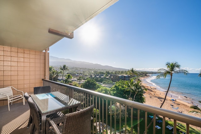 balcony with a beach view and a water and mountain view