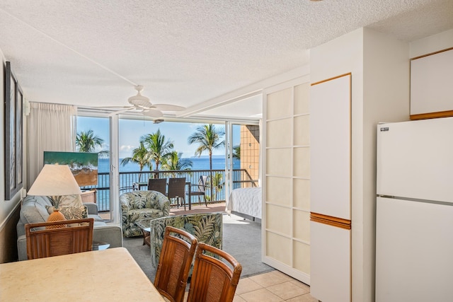 interior space with a water view, plenty of natural light, and ceiling fan