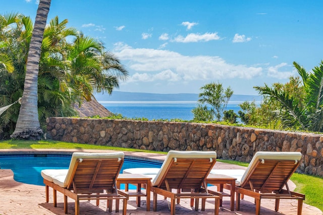 view of pool with a patio and a water and mountain view