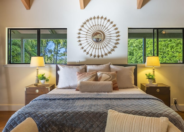 bedroom featuring beam ceiling, access to exterior, and hardwood / wood-style flooring