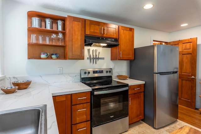 kitchen with light stone countertops, sink, stainless steel appliances, light wood-type flooring, and exhaust hood