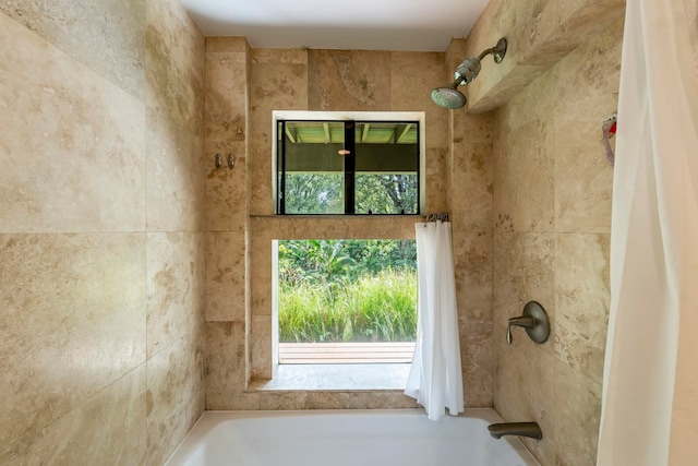 bathroom with shower / bath combo with shower curtain and plenty of natural light