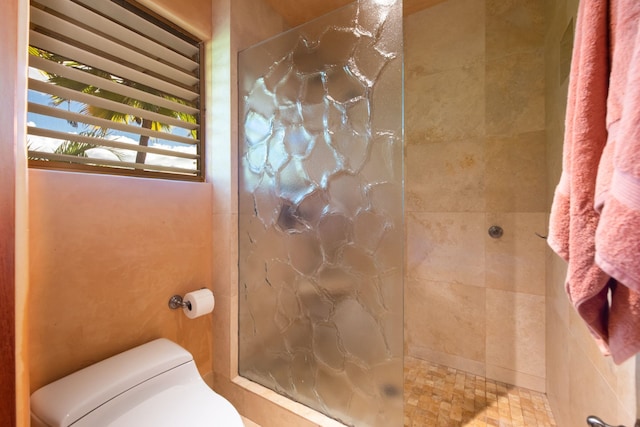 bathroom featuring toilet and tiled shower