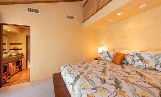 carpeted bedroom with high vaulted ceiling