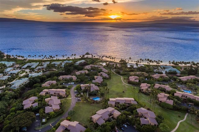 aerial view at dusk featuring a water view