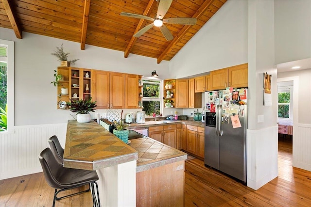 kitchen featuring wainscoting, wood ceiling, a peninsula, open shelves, and stainless steel refrigerator with ice dispenser