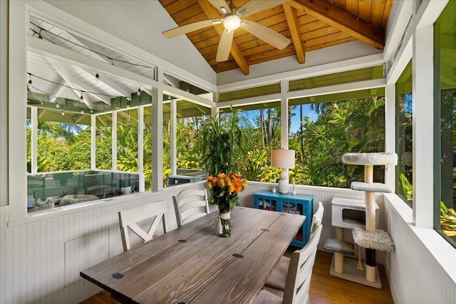 sunroom with outdoor dining area, a ceiling fan, and beam ceiling